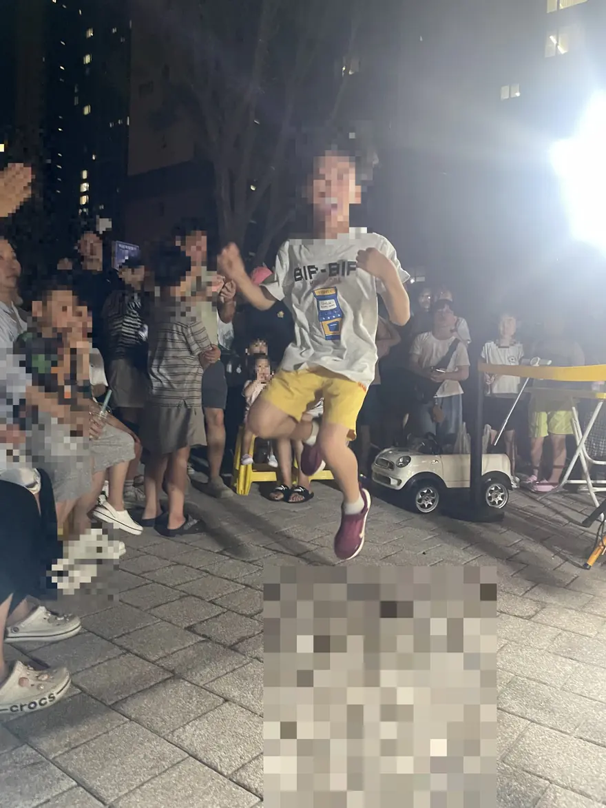 놀이기구 앞의 아이와 가족